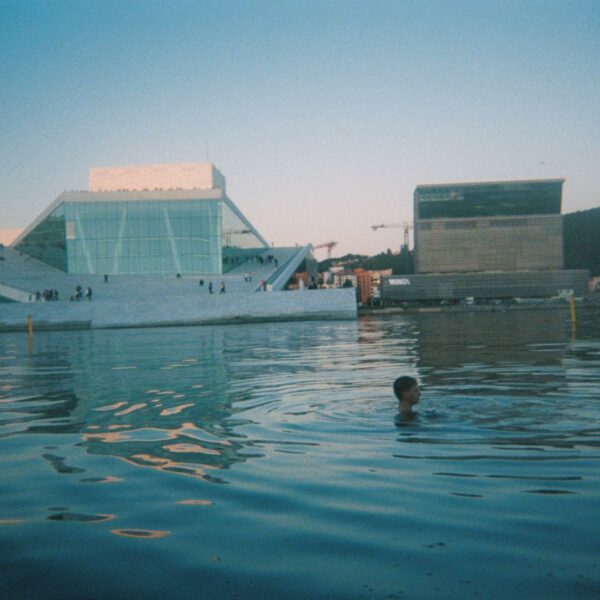 film photo of a person swimming near the oslo opera house