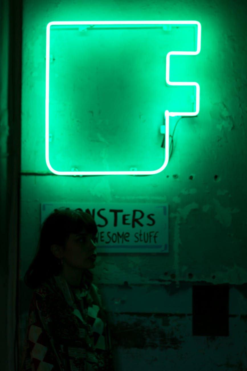 woman near building with neon signboard