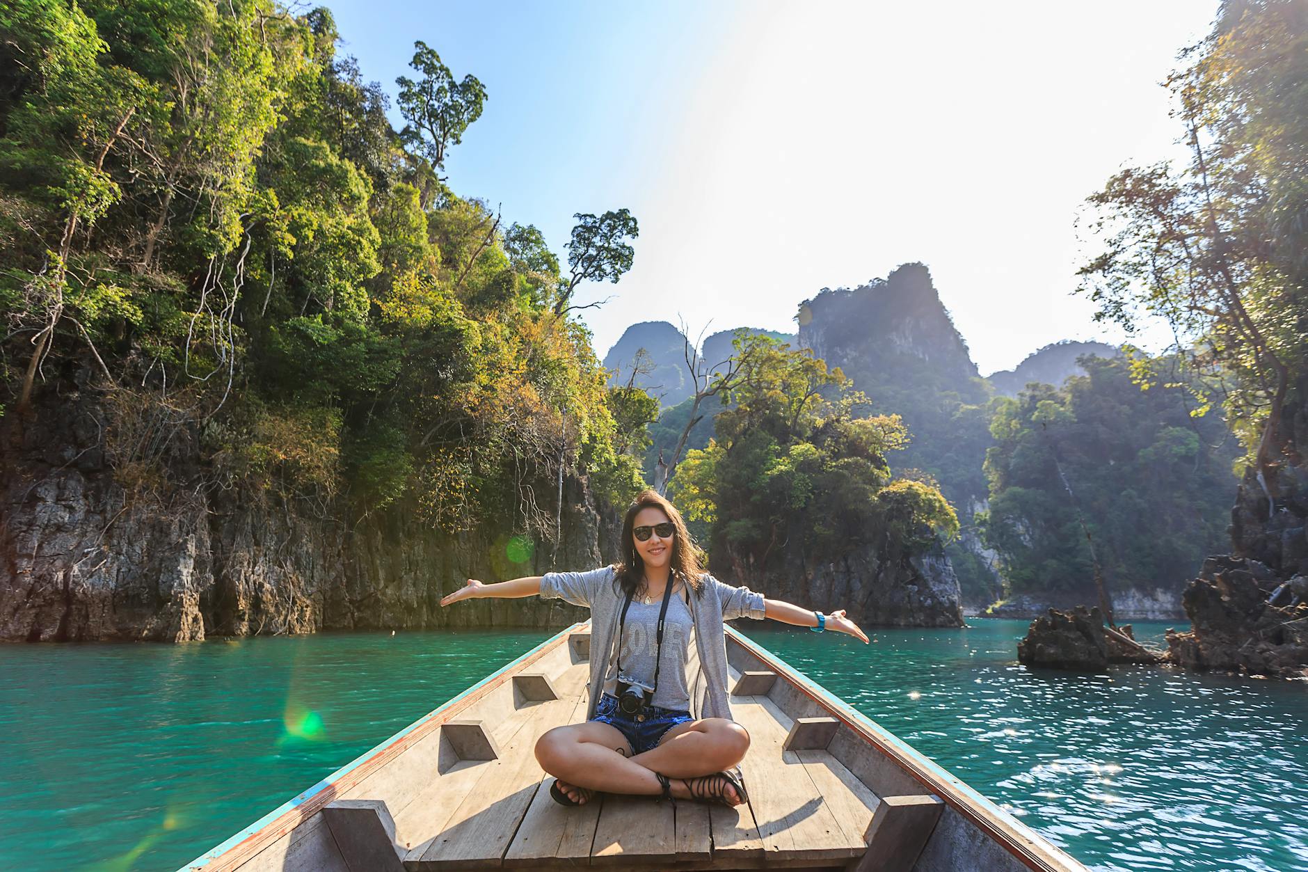 photo of woman sitting on boat spreading her arms